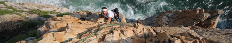 Mungo climbing with a camera on his back.