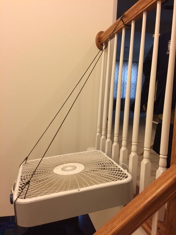 fan hung in stairway with paracord